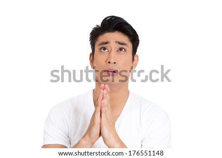 Closeup portrait of young man with open eyes looking up praying hoping for the best asking for forgiveness or miracle isolated on white background. Positive human emotion facial expression feelings