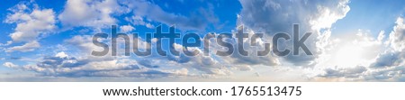 Panoramic view of blue sky with clouds and sun. Royalty-Free Stock Photo #1765513475