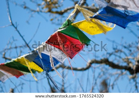 Tibetan prayer flags in closeup against a blue sky Royalty-Free Stock Photo #1765524320