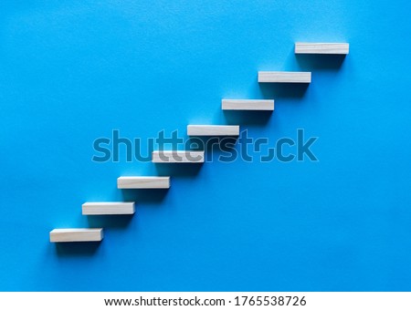 Wooden pegs forming a stairway. Wooden stairs elevate promotion of the business. Business promotion stairs to heaven. stairs to the blue sky. Wooden stairs. Business start up. Promotion and elevation. Royalty-Free Stock Photo #1765538726