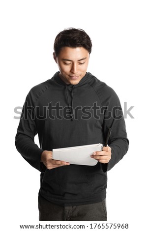 Japanese
student wearing a grey hoodie looking down on his exam
papers. Standing against a white background