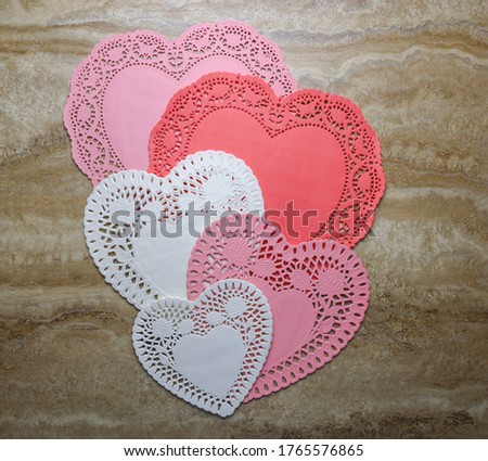 Heart shaped paper doilies in different sizes and colors.