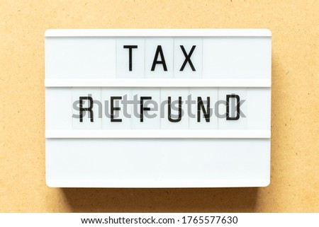 Lightbox with word tax refund on wood background