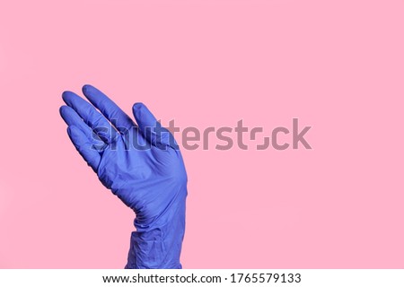 A hand in a latex surgical blue glove makes a hello gesture, bye. isolated