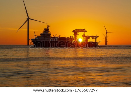 Beautiful sun set in the North Sea offshore wind farm Royalty-Free Stock Photo #1765589297