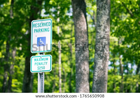Reserved parking handicap sign with beautiful tree bokeh