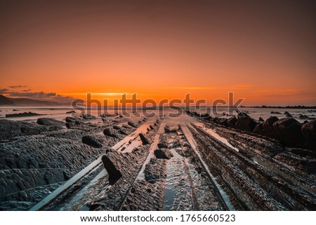 The incredible Flysch, a beautiful sunset in Sakoneta, is a beach in Deba. It is the western end of the Basque Coast Geopark, Guipuzkoa. Basque Country Royalty-Free Stock Photo #1765660523
