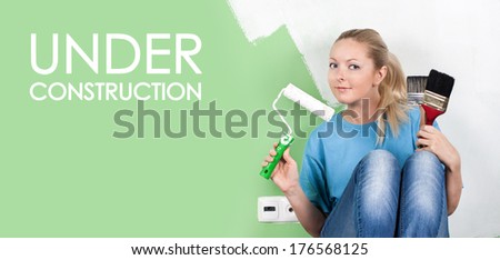 Young woman with paint tools in hands