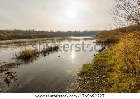 autumn landscape. river at sunset in the autumn forest. river going into the distance