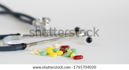 Medical concept with colorful pills and stethoscope on white. Close-up