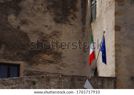 The flags of Italy and Europe are waving on the porch of the Pandone Castle of Venafro - Molise - Italy.