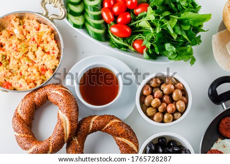 Set of a cup of tea, turkish bagel, salad and delicious meal in a pot on a white background. top view.