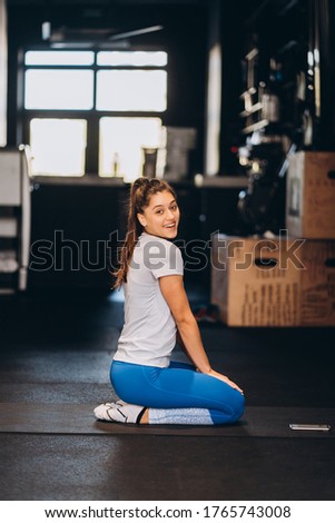 Young yoga woman kneeling on the floor.