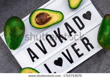 Avocado lover Written on a decorative panel among avocados, healthy eating and dieting concept, top view