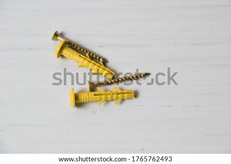 Yellow dowels on light wooden background with place for text.