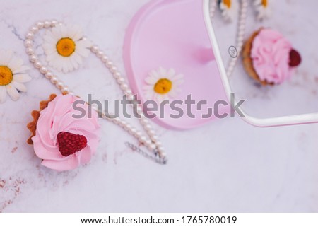 ornament of pearls on the table, a cake with raspberries