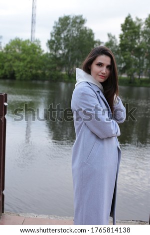 Portrait of a beautiful young woman in a white hoodie in a cityscape on the stairs