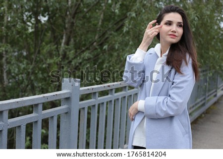 Portrait of a beautiful young woman in a white hoodie in a cityscape on the stairs