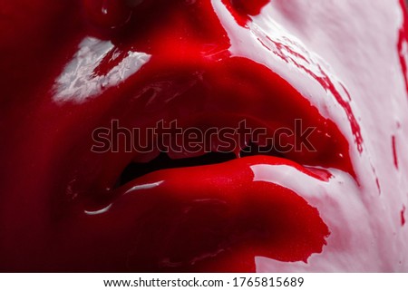 Photo of a female's lips with glossy red paint