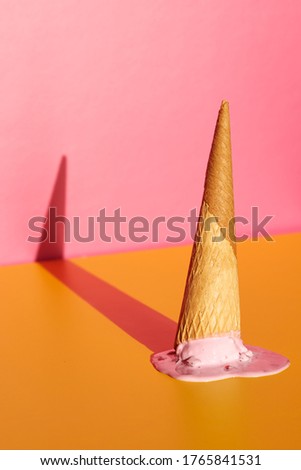 Strawberry ice cream cone on a yellow and pink background. The image has space for text.