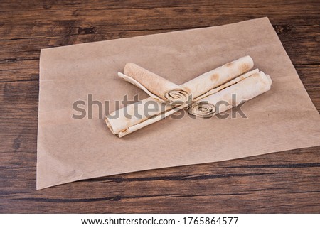 Thin pita bread rolled up on baking paper. Lavash.