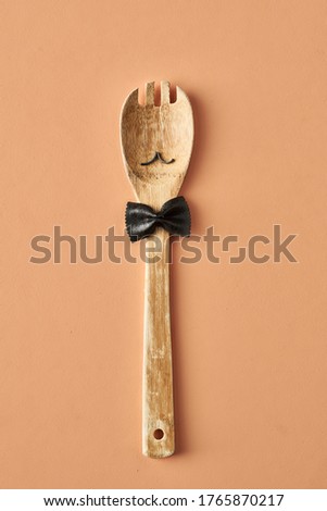 Cartoon man with a mustache from farfalle pasta and wooden spoon, conceptual photography for food blog or ad