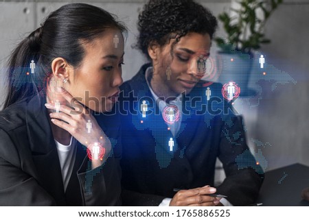 Two businesswomen work together in modern office on new project. Double exposure. Concept of success. Planet earth world map.