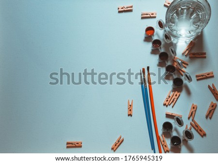 White background with side painting tools and clothespins.