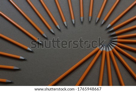 Lead pencils in orange, arranged in a spiral.