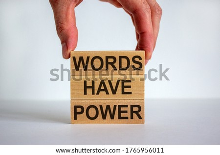 Male hand placing a block with word 'words' on top of a blocks tower with words 'have power'. White table. Beautiful white background. Copy space. Business concept. Royalty-Free Stock Photo #1765956011