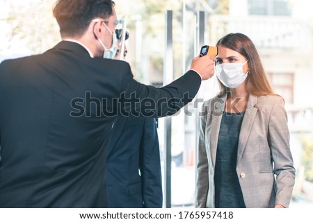 Body temperature check, prevent virus Concepts in preventing contagious diseases. Corona virus [Covid-19] . social distancing concept.Operator Check Fever by Digital Thermometer Visitor Royalty-Free Stock Photo #1765957418