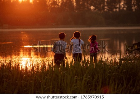 Children run at sunset in the summer.