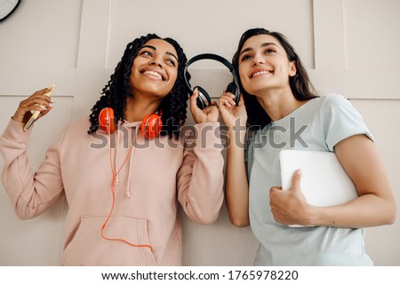Smiling women in headphones listening to music