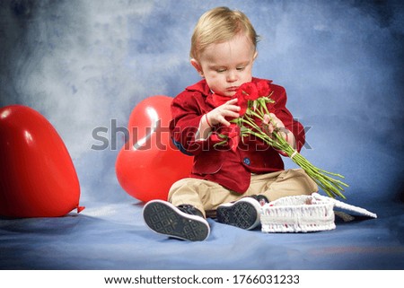  A blond baby boy gives flowers for mother's day.