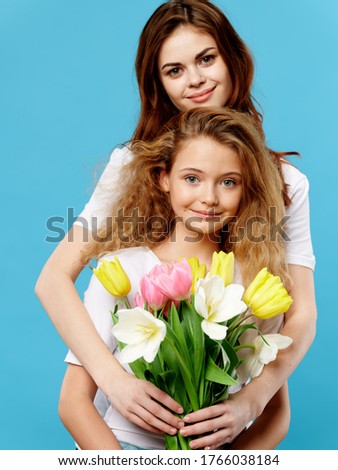 Mom and daughter hugs flowers holiday