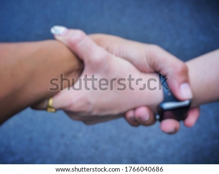 The pictures blur Two hands helping another and coming togetheragreement ,teamwork.