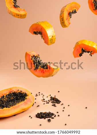 A papaya fruit cut in slices floating in the air, tropical fruit image Royalty-Free Stock Photo #1766049992