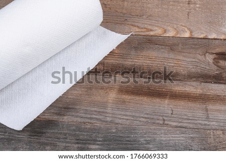 White roll of napkins on a dark wooden background