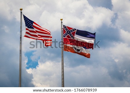 Flags of the United States, State of Mississippi and City of Brandon, MS waving in the wind against blue sky with clouds