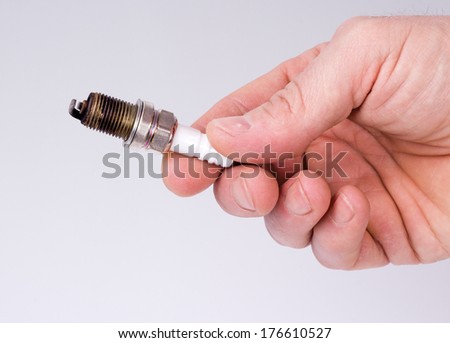 Hand man holding a used spark plug on white background