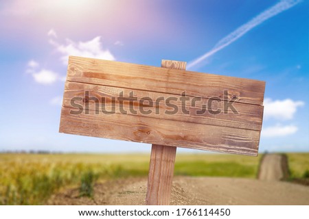 Wooden empty road sign on the nature background