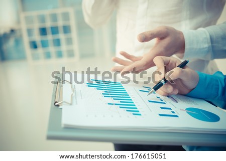 Closeup image of a business consultant explaining the financial aspects to the colleague on the foreground  Royalty-Free Stock Photo #176615051