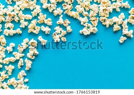 Popcorn frame on blue background top view copy space