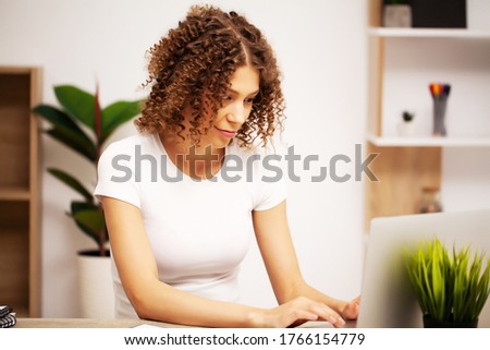 Beautiful business woman with a smile on her face working in the office on a laptop