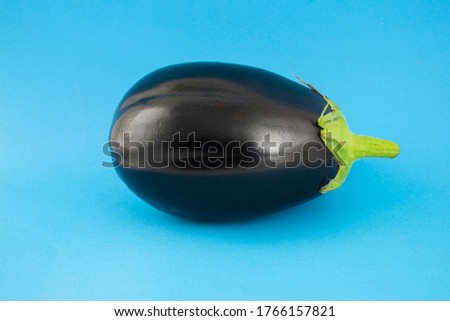 Eggplant or aubergine (melanzana) vegetable isolated on blue background. A gourmet ingredient for fresh summer salad's recipe