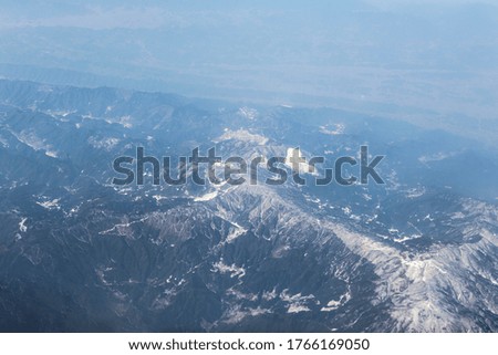 bird eyes view of high hill mountain with little foggy and a bit cover by snow