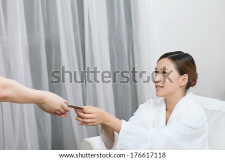 	A spa young woman handing out a bank card	