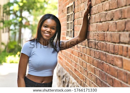 A Outdoor portrait of a Young black African American close to a brick wall