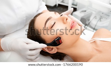 Beautician doing skin treatment using a microneedle derma roller. Woman getting procedure skincare, with mezzo skin roller Royalty-Free Stock Photo #1766200190