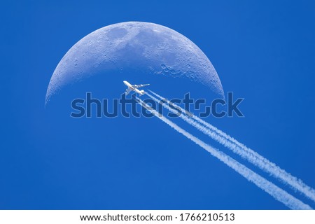 Passenger plane - airliner passes near the moon. Explore new frontier. Space traveler concept Royalty-Free Stock Photo #1766210513